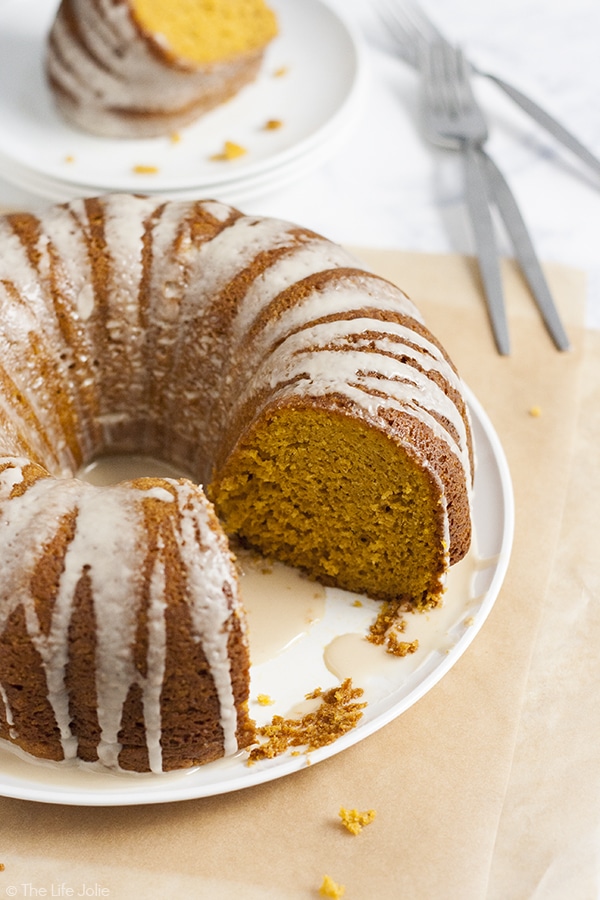 A pumpkin coffee cake with a slice cut out of it revealing the moist center of it.