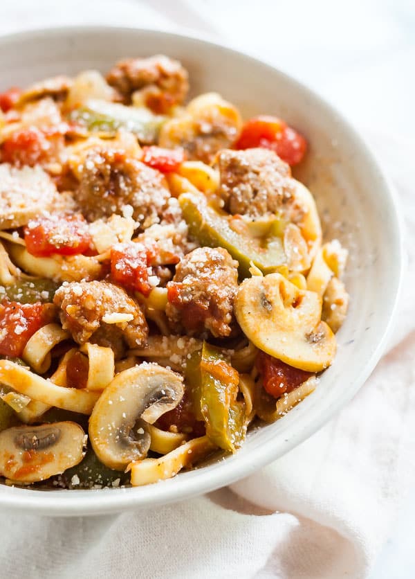 A close of of one side of a bowl of Sausage and peppers pasta.