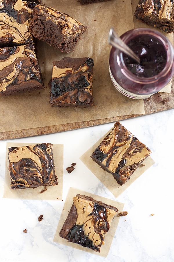 These homemade PB&J Brownies are an easy and delicious holiday dessert option. Chewy, fudgey chocolate brownies with a swirl of peanut butter and the fruit spread of your choice on top, these are made from scratch and would be great on a Thanksgiving of Christmas dessert table or just because you deserve a tasty dessert!