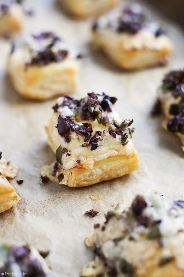 This Olive and Gruyere Puff Pastry Tartlets recipe is one of my new favorite easy appetizers to throw together! Just four simple ingredients (including frozen puff pastry dough, olives and cheese) and they come together quickly for the holidays or any parties you may be having!