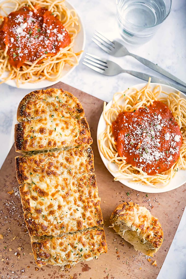This homemade Three Cheese Garlic Bread recipe is a super easy accompaniment to a delicious Italian meal (or any meal for that matter!). It's really quick to spread with butter, herbs and a ton of melted cheese and pre-cut so that it's even easier to pull apart and enjoy with dinner! This is a major family favorite!