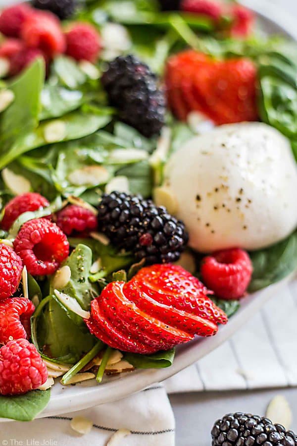 A close up of the strawberry in the Summer Berry and Burrata Salad.