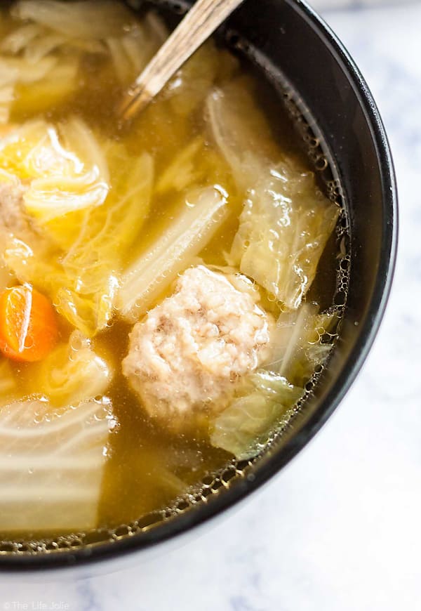 A close up shot of a meat ball in the Cabbage and Pork Meatball Soup.