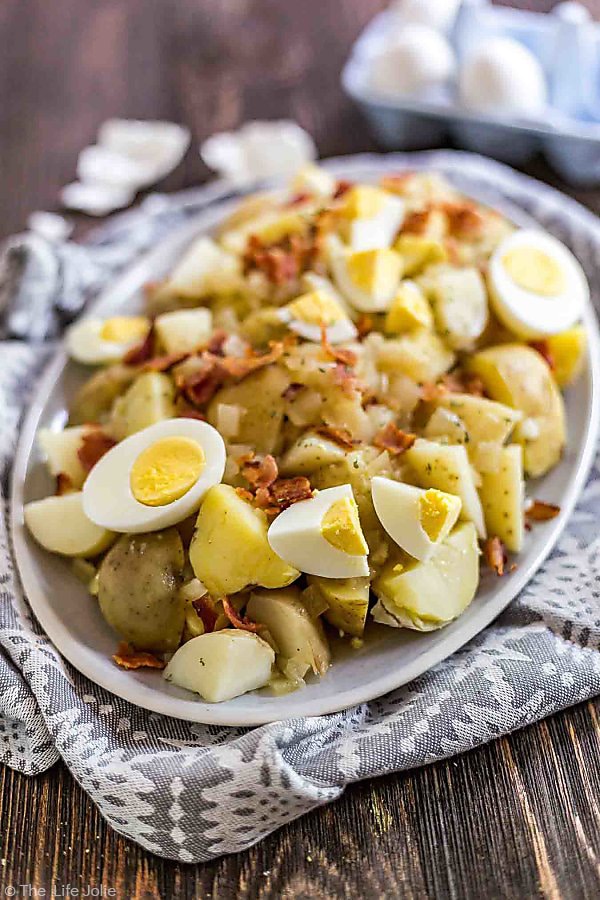 German Potato Salad on a gray towel with eggs and egg shells in the background.
