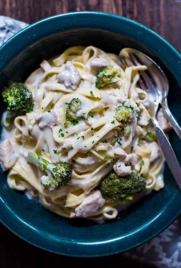 A close up overhead image of Creamy Chicken and Broccoli Pasta with a spoon and fork in it.