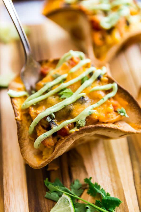 A close up shot of Cheesy Chicken Taco Bowls with a fork in them.
