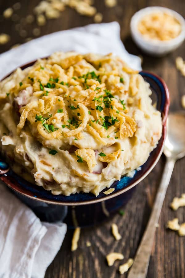 French Onion Creamy Mashed Potatoes in a blue bowl with a spoon on the side of it.